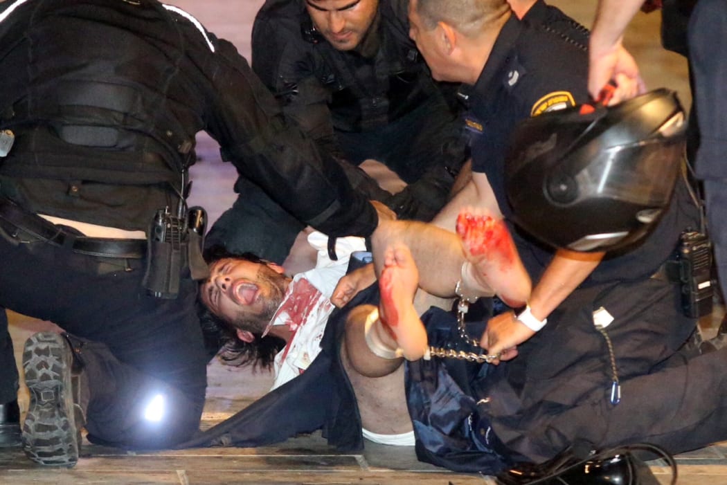 Police apprehend a suspect at the scene of the shooting in Tel Aviv.