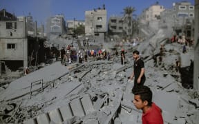 10/26/2023, Gaza, Palestine.  After the Israeli airstrike on the 20th day of the conflict in the city of Khan Yunis, the landscape is one of devastation. Many buildings now stand as little more than rubble, while others are heavily damaged. In this dire situation, brave individuals are working tirelessly to rescue survivors and recover the bodies of those who may have tragically perished in the debris of the destroyed houses. (Photo by Mohammad Zanoun / Middle East Images / Middle East Images via AFP)