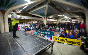 Justin Latif, #parkupforhomes organiser, speaks to people who have come to the event at Mangere Town Centre.