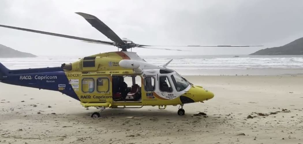 A rescue helicopter is seen on the central Queensland coast, where its crew rescued a man in his 70s who swam nine hours through the night after falling from his catamaran in rough conditions.