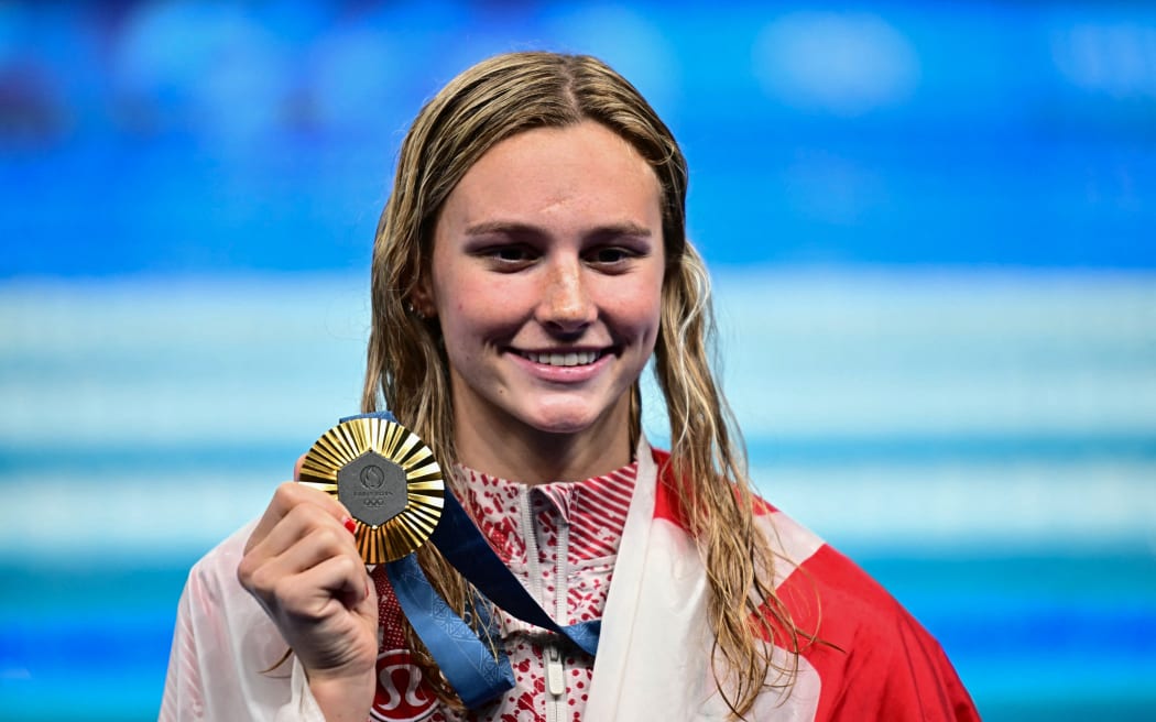 Gold medallist Canada's Summer Mcintosh celebrates during the podium ceremony of the women's 200m individual medley swimming event during the Paris 2024 Olympic Games at the Paris La Defense Arena in Nanterre, west of Paris, on August 3, 2024. (Photo by Manan VATSYAYANA / AFP)