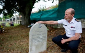 Warrant Officer Ken Bancroft, who is leading the vigil team of Royal New Zealand Navy sailors, at the headstone of Engine Room Artificer Apprentice Philip Short.