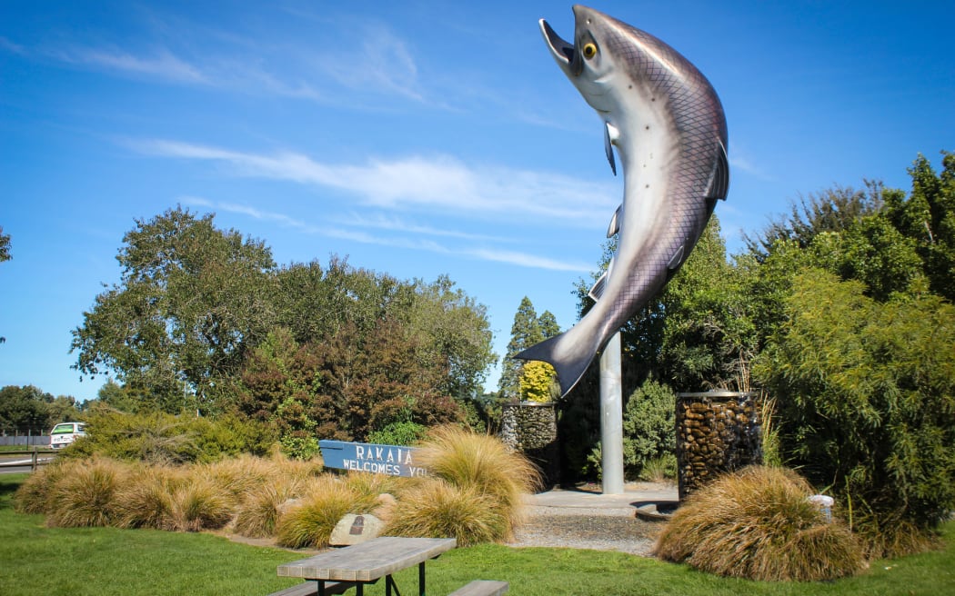 Large sculpture of trout behind welcome town sign for Rakaia