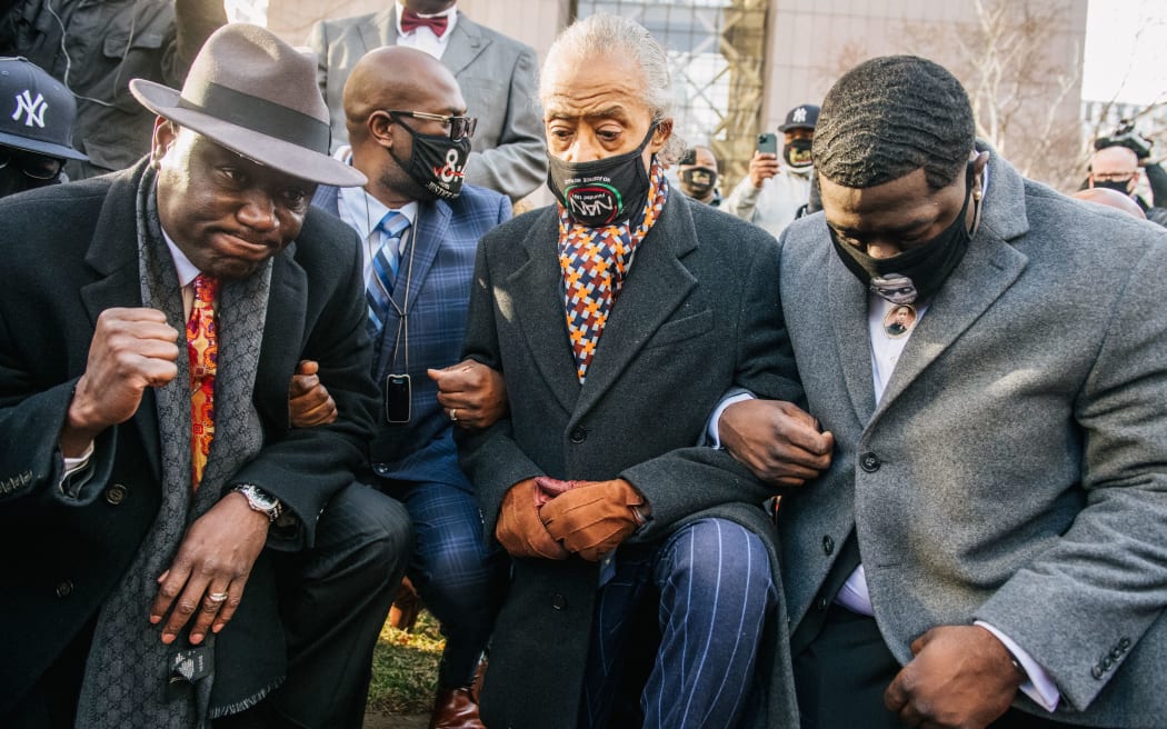 Attorney Ben Crump (L), Rev. Al Sharpton (C) and the family of George Floyd kneel for 8:46 seconds during a news conference on March 29, 2021 in Minneapolis, Minnesota.