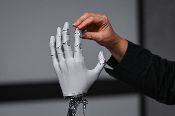 A journalist touches Xpeng's next-gen Iron humanoid robotic hand at its headquarter in Guangzhou, in southern China's Guangdong province on November 6, 2025.