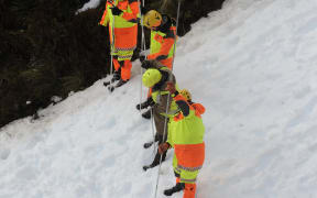 A photo released by police shows search and rescue workers near the site of the avalanche in Fiordland National Park.