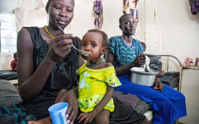 A mother gives food to her child with malnutrition in a clinic in Old Fangak, Jonglei state