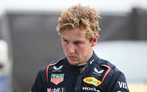 Red Bull Racing's New Zealand driver Liam Lawson walks back to his team garage after getting out of his car at the end of the Formula One Chinese Grand Prix in Shanghai on March 23, 2025. (Photo by GREG BAKER / AFP)