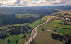The Wai-iti River after flooding in the Tasman region in June 2025. A damaged cycle bridge for the Great Taste Trail, can be seen in the middle of the photo.