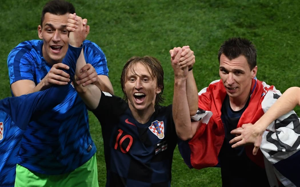 Croatian midfielder Luka Modric (C) and forward Mario Mandzukic (R) celebrate after winning the Russia 2018 World Cup semi-final football match against England.