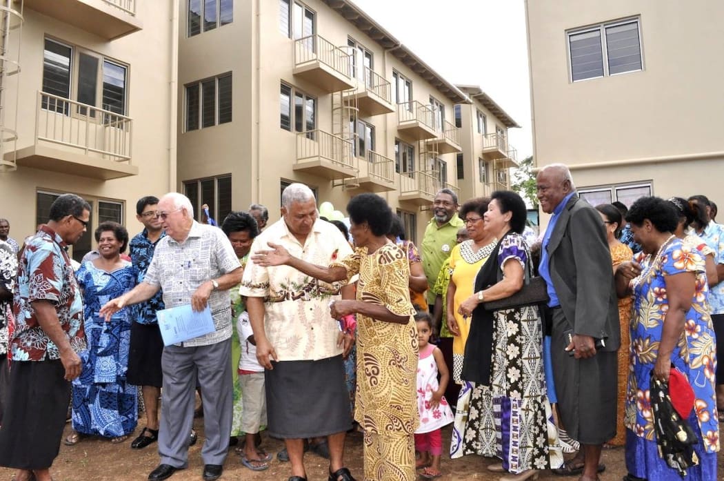 Father Kevin Barr and Prime Minister Frank Bainimarama with residents at the launch of the housing project in 2013.
