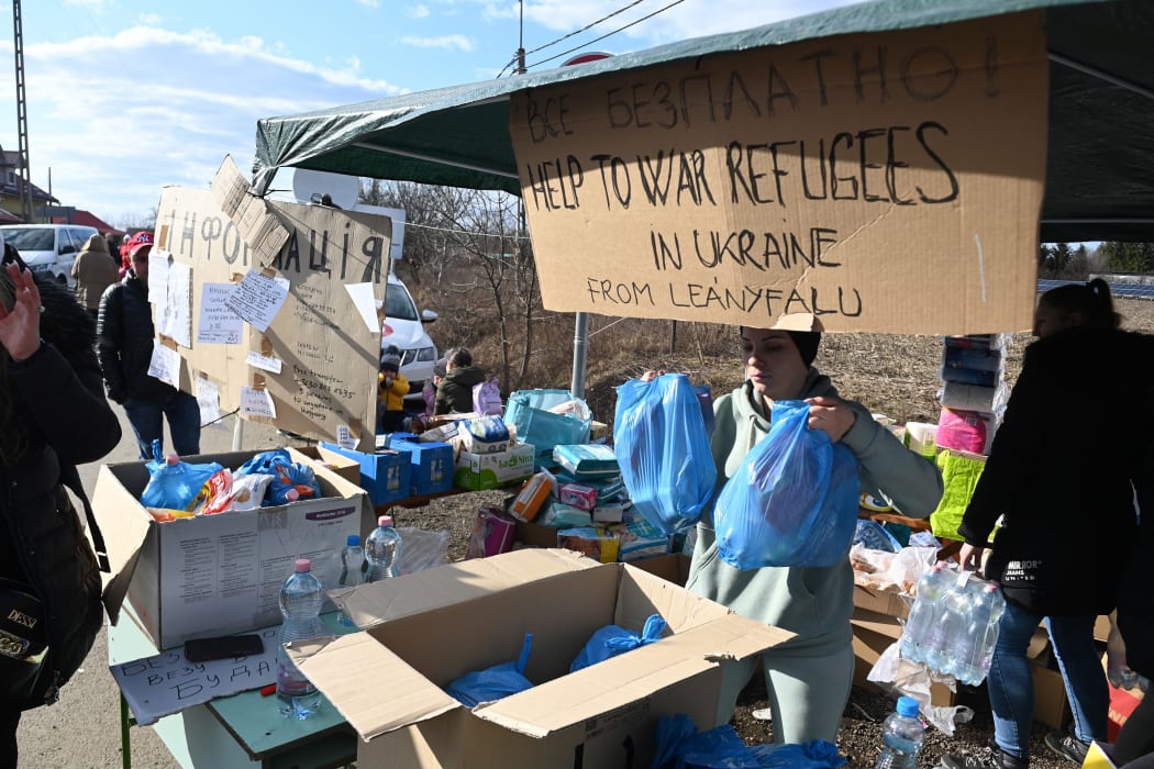 A Hungarian volunteer works at a booth where drinks and other goods are offered to Ukrainian refugees crossing the Ukrainian-Hungarian border in Tiszabecs, Hungary, on February 27, 2022.