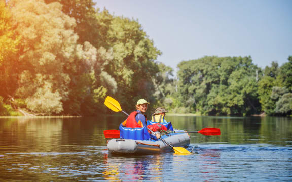 A photo of a happy Kid kayaking with his sister on the river. Active girl having fun enjoying adventurous experience with kayak on a sunny day during summer vacation