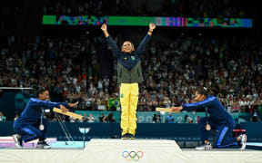 (LtoR) US' Simone Biles (silver), Brazil's Rebeca Andrade (gold) and US' Jordan Chiles (bronze) pose during the podium ceremony for the artistic gymnastics women's floor exercise event of the Paris 2024 Olympic Games at the Bercy Arena in Paris, on August 5, 2024. (Photo by Gabriel BOUYS / AFP)