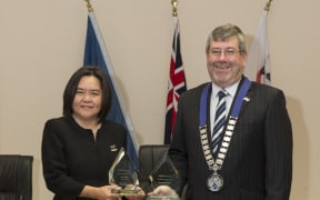 Gigi Crawford of Zealong Tea Estate and Mayor Allan Sanson of Waikato District Council, with the three trophies won by Zealong Tea Estate