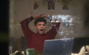 Tired young man working late from home on laptop in office window. (Photo by Sam Edwards/CAIA IMAGE/SCIENCE P / NEW / Science Photo Library via AFP)