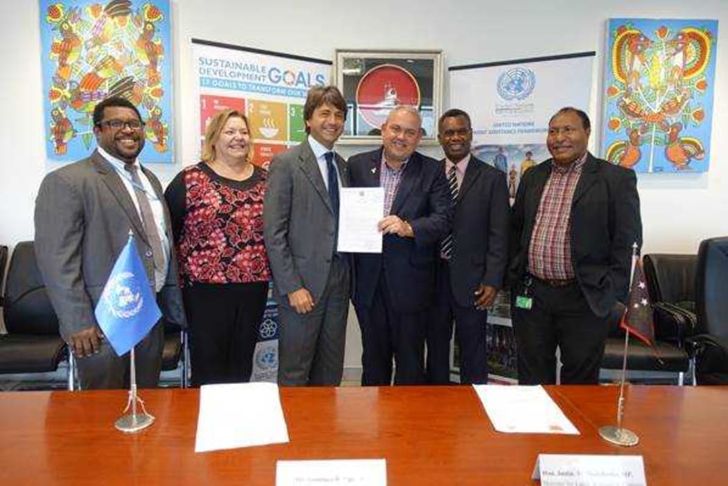 Gianluca Rampolla, United Nations Resident Coordinator in PNG, handed a special land lease by PNG's Minister for Lands & Physical Planning Justin Tkatchenko