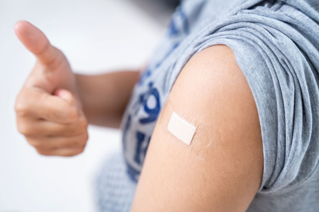 Close up of teens girls in the shoulder with plaster on arm after vaccination in hospital
