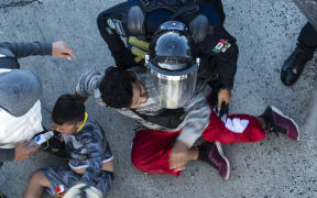 Central American migrants are stopped by Mexican police forces as they reach the El Chaparral border crossing, in Tijuana, Baja California State, Mexico, on November 25, 2018.