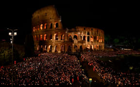 Faithful hold candles outside the Colosseum during the Way of the Cross (Via Crucis) as part of Good Friday during the Holy Week in Rome on 18 April, 2025.