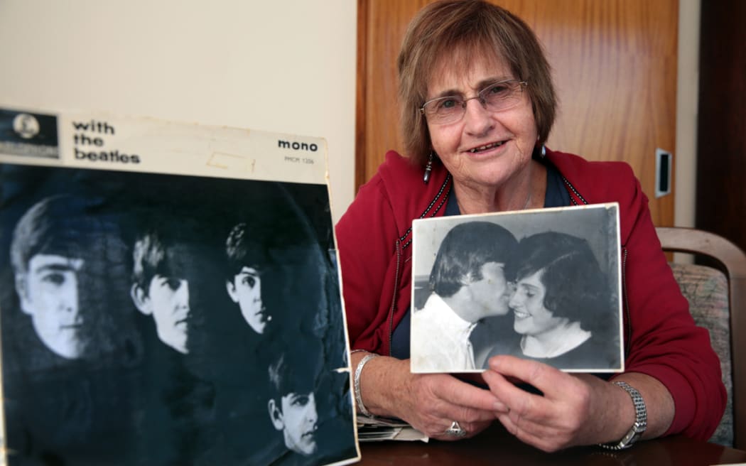 Lynda Mathews holding the photo with John Lennon.