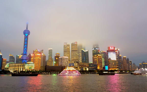 Tall buildings and night time lights of Shanghai from across the water.