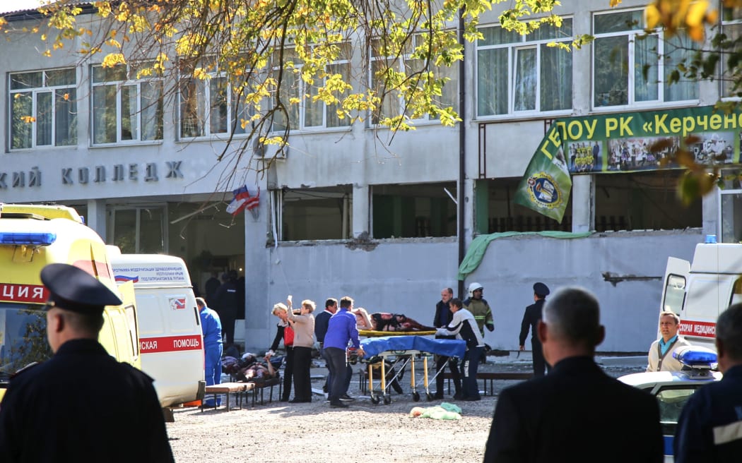 Rescuers carry an injured victim out of the college.