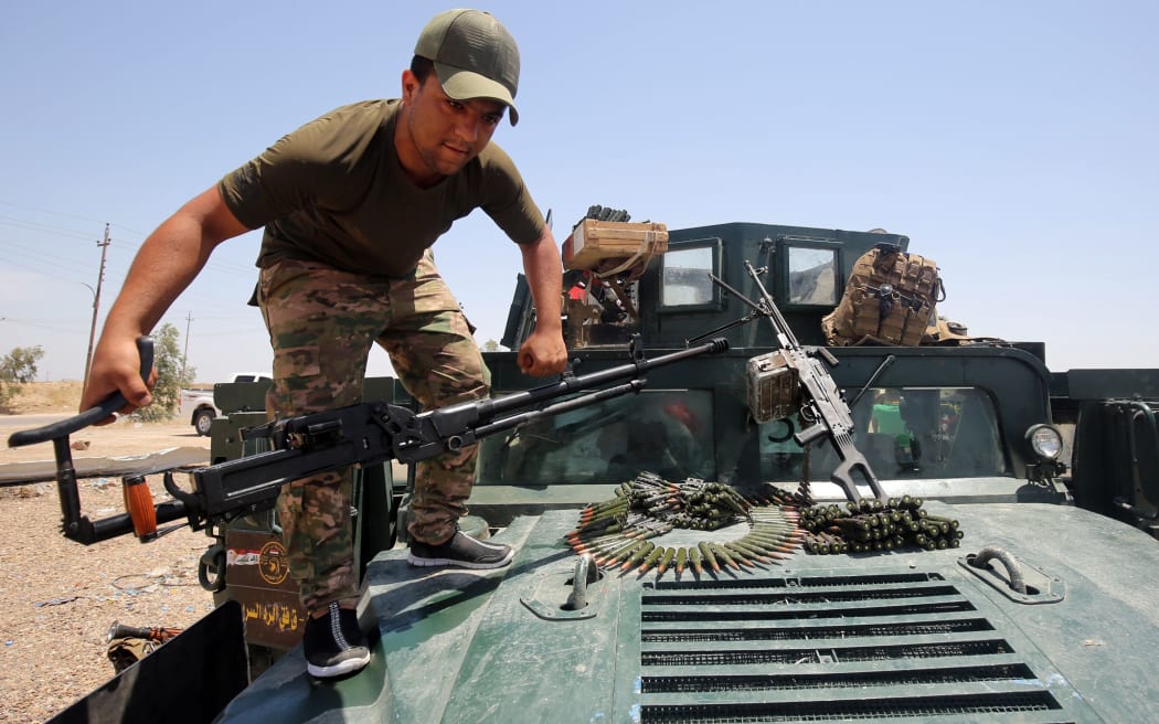 A member of the Iraqi security forces mounts a gun atop a vehicle as they gather on the outskirts of Fallujah as they prepare an operation aimed at retaking the city from the Islamic State (IS) group, on May 22, 2016.