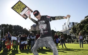 Refugee Quote Protest. A man holds a sign saying "I support doubling New Zealand's refugee settlement quota" and the Holy Bible