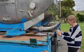 Jean McIver fills up at a tanker of drinking water on the roadside in Ōtāne in central Hawke's Bay.