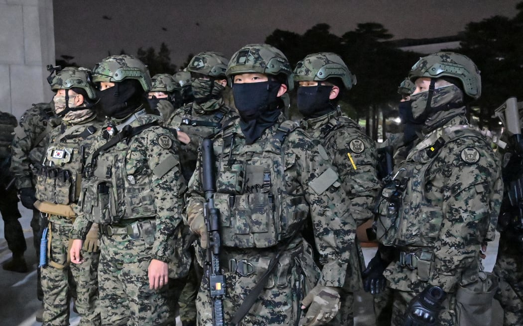Soldiers try to enter the National Assembly building in Seoul on December 4 2024, after South Korea President Yoon Suk Yeol declared martial law. - South Korea's President Yoon Suk Yeol on December 3 declared martial law, accusing the opposition of being "anti-state forces" and saying he was acting to protect the country from "threats" posed by the North. (Photo by Jung Yeon-je / AFP)