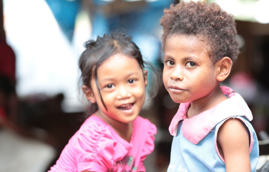 Indonesian and West Papuan girls play in a market in Jayapura.