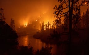 Flames burn down to the Klamath River as the McKinney Fire rages in Klamath National Forest, northwest of Yreka, California, on 31 July 2022.
