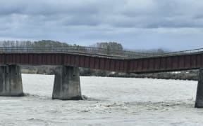 A 610m-long rail bridge over the Rangitata River, South Canterbury, sags after flood water washed away one of 34 piers.
