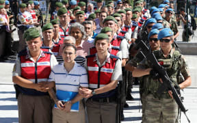 Defendants arrive at court for their trial, being held at Akinci airbase outside of Ankara