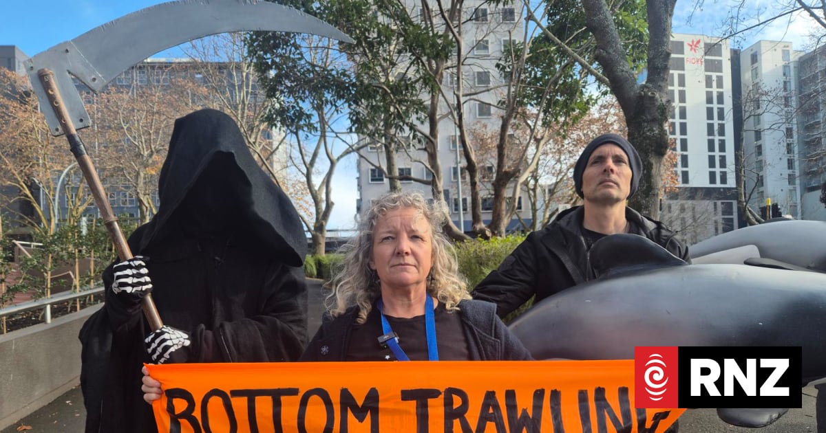 Shane Jones faces person dressed as Grim Reaper outside environment conference