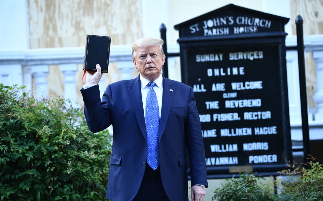 US President Donald Trump holds up a bible in front of St John's Episcopal church.