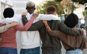 Back view of international group of people making strike on the street, hugging, showing their strong unity, demanding from government saving planet, reducing pollution.