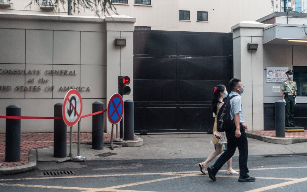 People walk past the entrance of the US consulate in Chengdu, southwest China's Sichuan province. China ordered the consulate's closure in retaliation after the US shuttered Beijing's diplomatic mission in Houston.