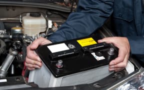 7909492 - a car mechanic replaces a battery.