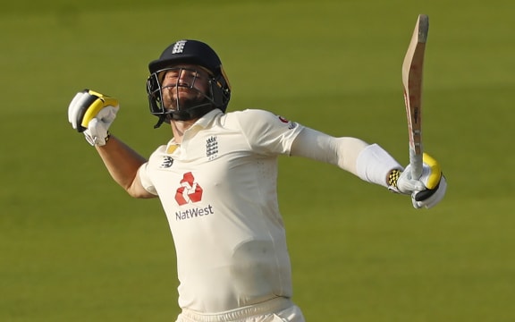 England's Chris Woakes celebrates after hitting the winning runs during play on the fourth day of the first Test cricket match between England and Pakistan at Old Trafford in Manchester on August 8, 2020.(Photo by LEE SMITH / POOL / AFP)