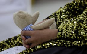 A young refugee who fled Afghanistan after the takeover of her country by the Taliban, holds a small teddy bear at the International Humanitarian City (IHC) in the Emirati capital Abu Dhabi, as she waits to be transferred to another destination, on August 28, 2021. (Photo by Giuseppe CACACE / AFP)