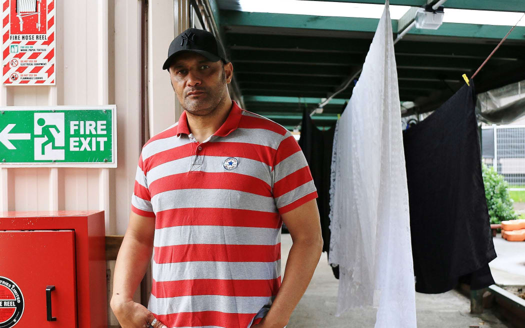 Manin red stripely t shirt by washing line.
