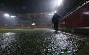 A  security guard walks off a flooded Suncorp Stadium  following the postponement of the ANZAC Test to Sunday 3rd May, Brisbane ,Australia on May 1, 2015.