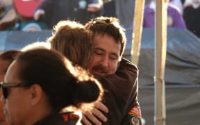 Two people embrace in a hug.