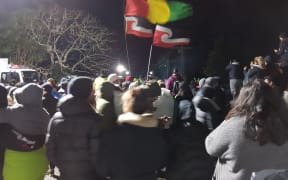 Flags fly at Ihumatao on Monday evening after police ramped up their presence.
