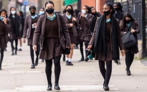Students of Notre Dame secondary school walk out from the building after the first day at school  in southern London as schools in England reopen on March 8, 2021.