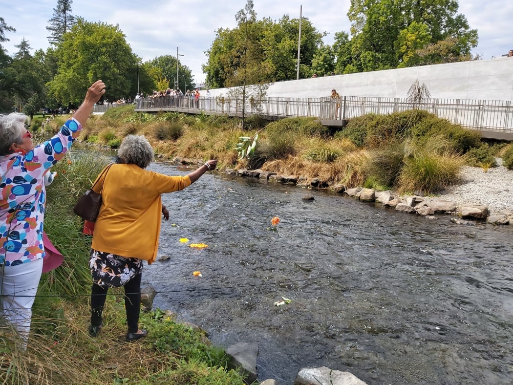 People throw flowers into the River of Flowers.