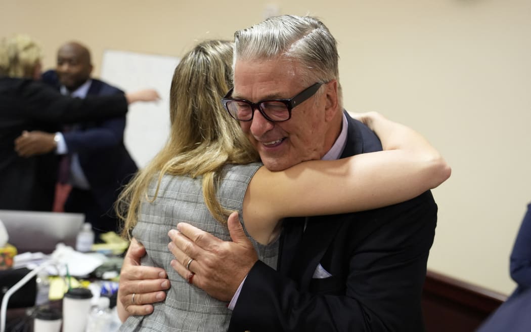 US actor Alec Baldwin hugs a member of his legal team at the conclucion of his trial on involuntary manslaughter at Santa Fe County District Court in Santa Fe, New Mexico, on July 12, 2024. Baldwin's trial for involuntary manslaughter was dismissed by a judge Friday after she ruled that key evidence over a fatal shooting on the set of "Rust" had been withheld from the defense. (Photo by RAMSAY DE GIVE / POOL / AFP)