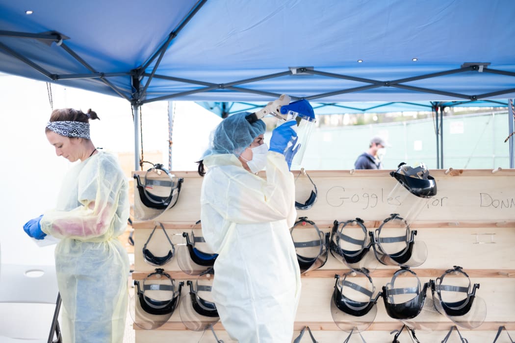 Medical workers putting on PPEs at the beginning of their shift at the emergency field hospital run in Central Park on April 08, 2020 in New York, United States.